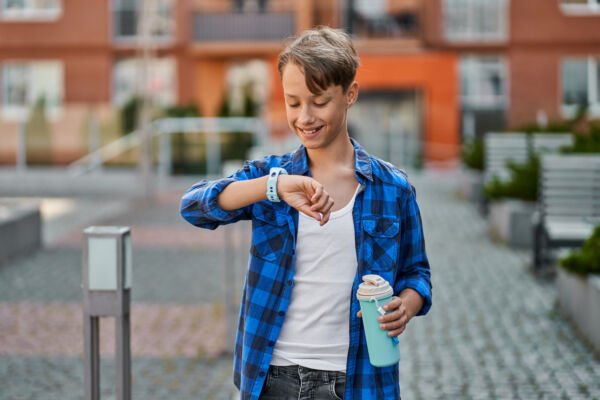Особенности детских часов 9 little boy speaking by blue smartwatch drink tea near school